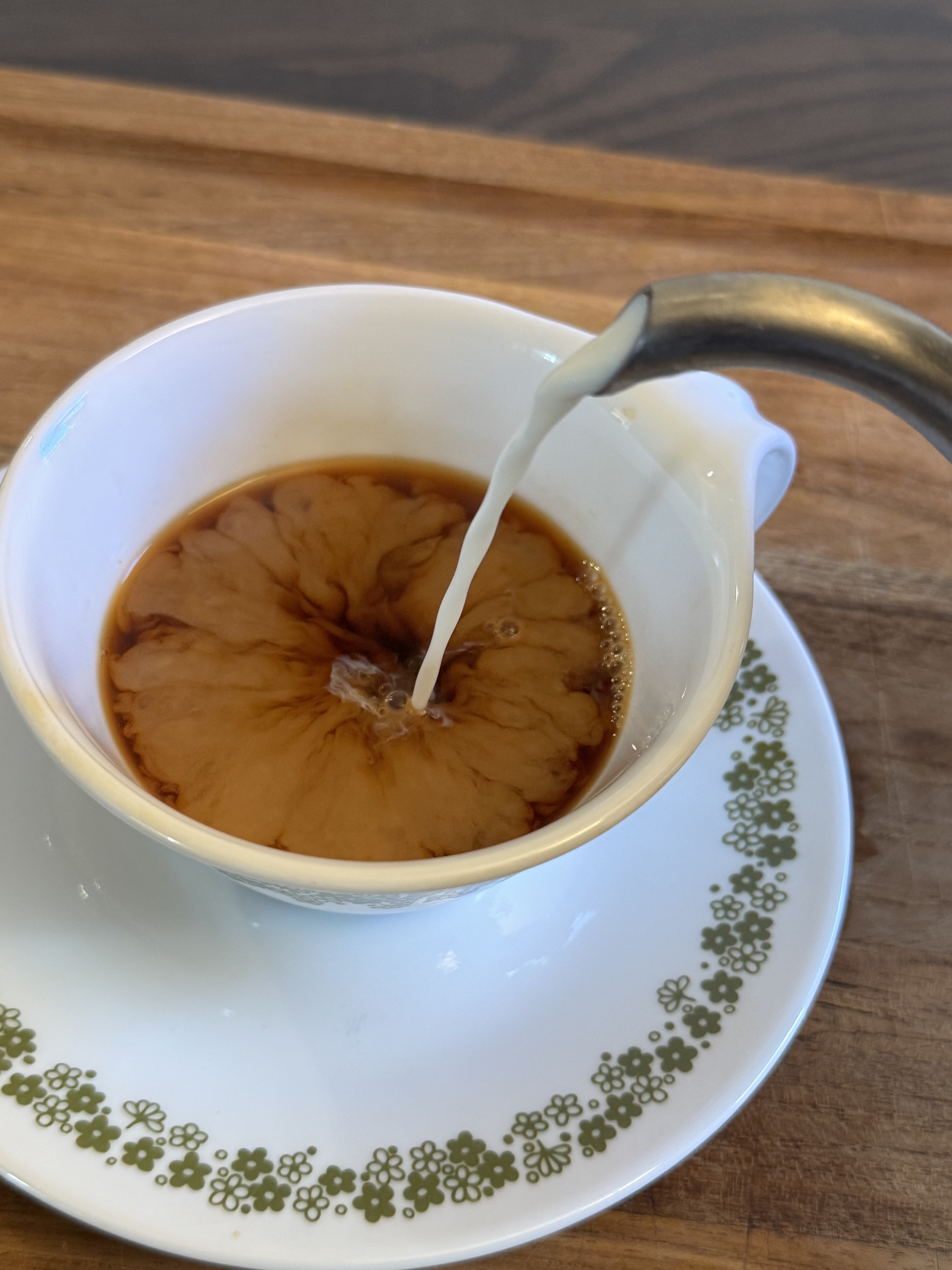 Perfect cup of authentic chai in elegant china cup with golden tea and milk swirls